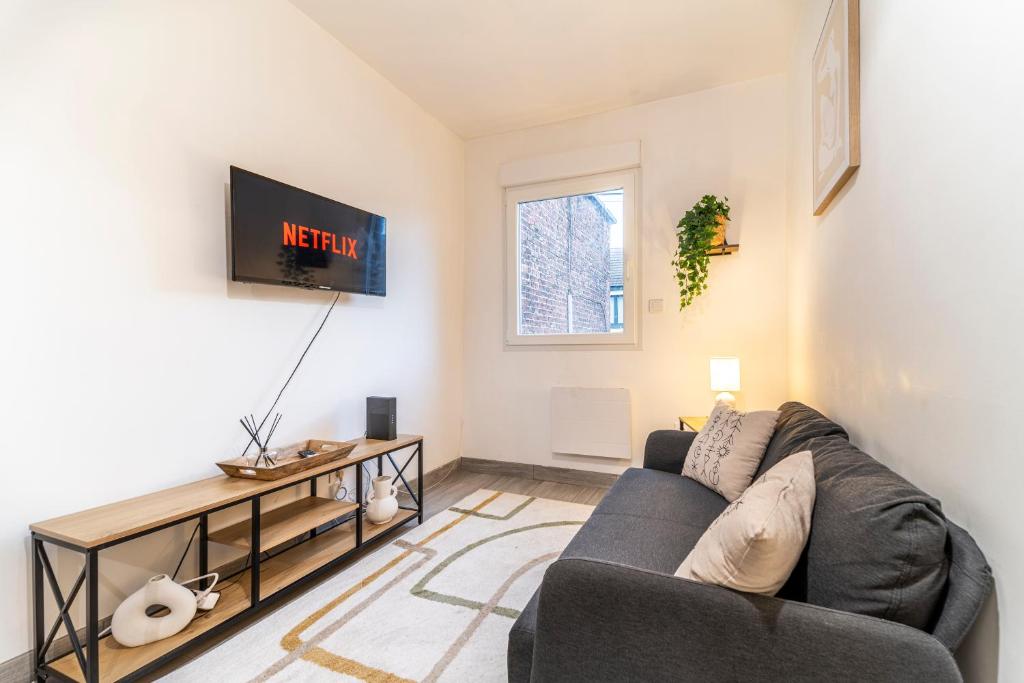 a living room with a couch and a tv at L'Odyssée - Mercure - Gare - Wifi - Netflix in Tourcoing