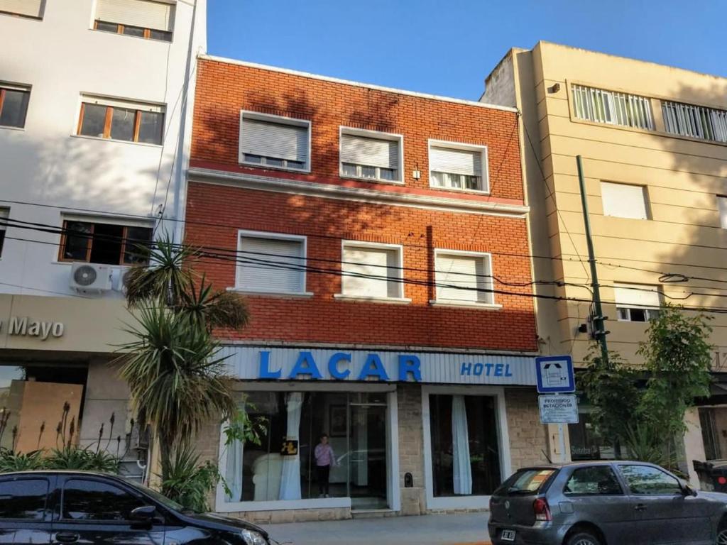 un edificio en una calle con coches aparcados delante en Hotel Lacar, en Mar del Plata