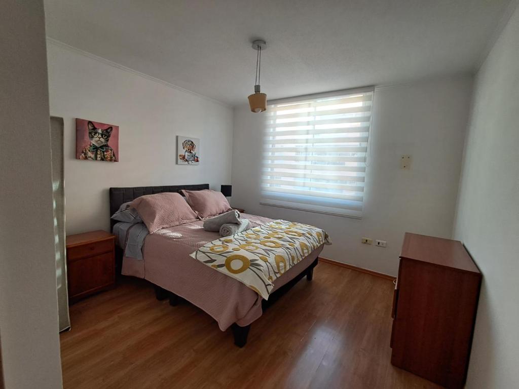 a bedroom with a bed with a large window at Sector Norte 1 Dormitorio in Antofagasta