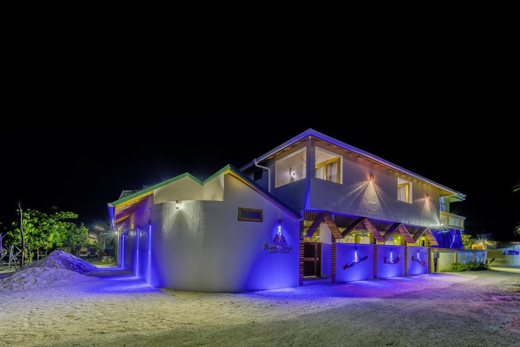 a house is lit up in blue at night at Ameera Maldives in Dhiffushi