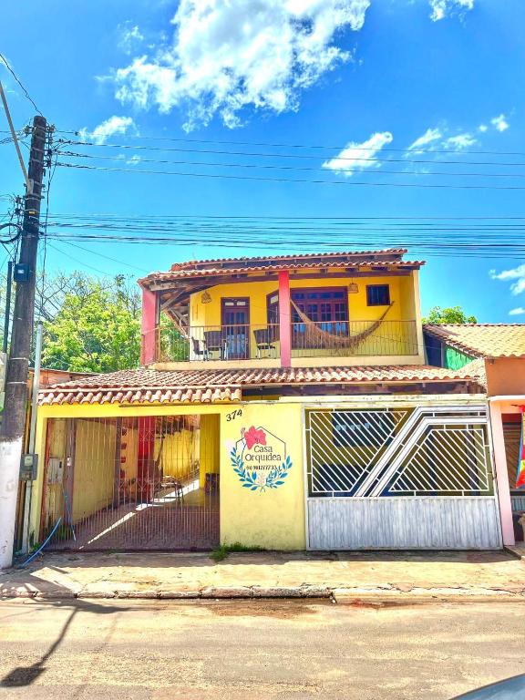 a yellow building with a balcony on a street at Casa Orquídea Alter do Chão in Alter do Chao