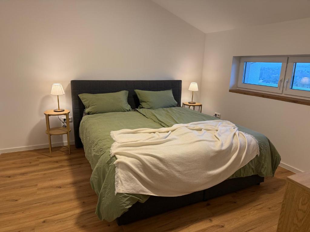 een slaapkamer met een groot bed met twee lampen bij Leni Vacation Rental in Hattert