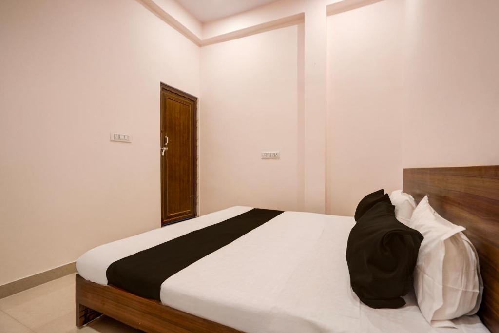 um quarto com uma cama com lençóis brancos e pretos em Hotel O Haven Palace em Alambagh