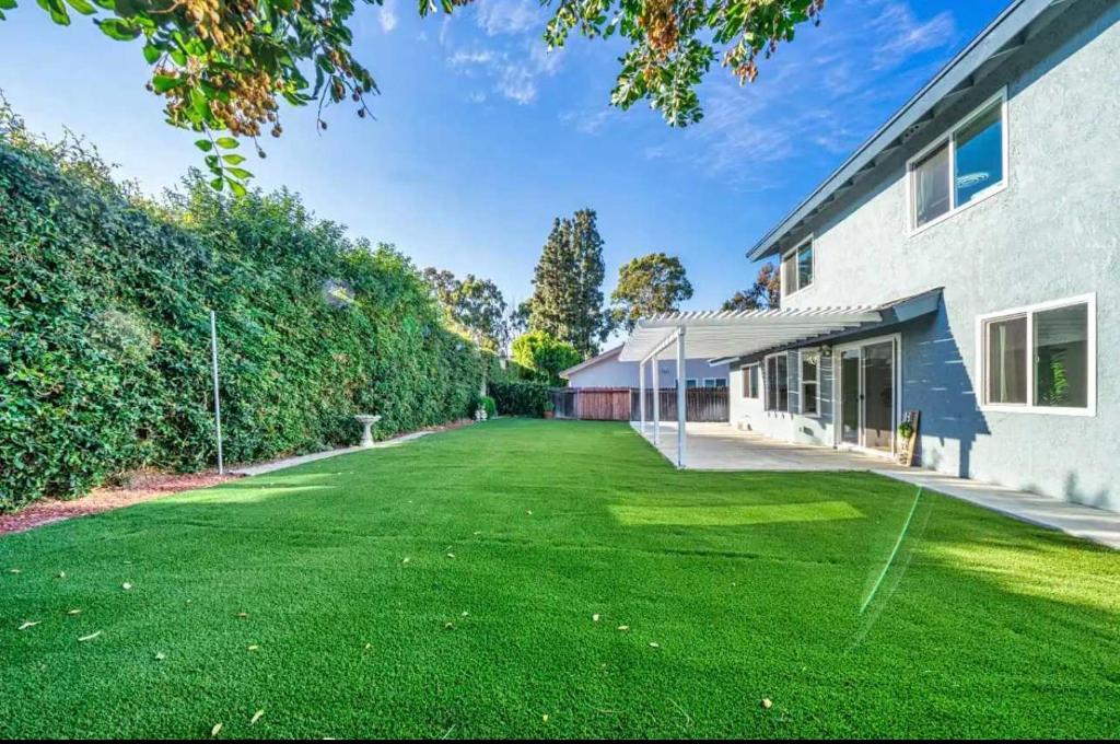 ein großer Garten mit grünem Gras neben einem Gebäude in der Unterkunft Marbella Lane Modern Home w Private Backyard in La Habra