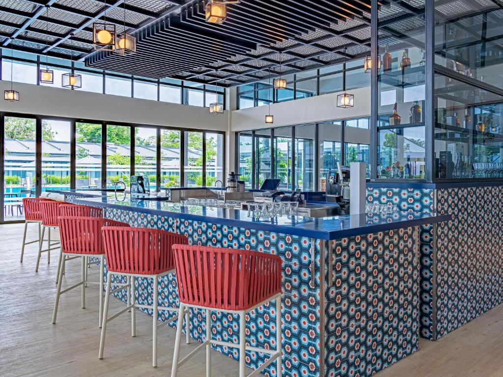 セパンにあるibis Styles Sepang KLIAの赤い椅子付きのバーのあるレストラン