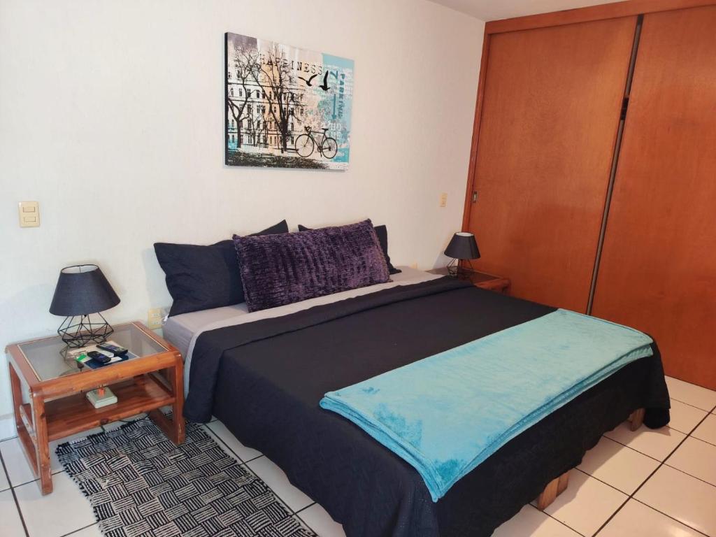 a bedroom with a bed and a table with a night stand at Casa Luna in Morelia