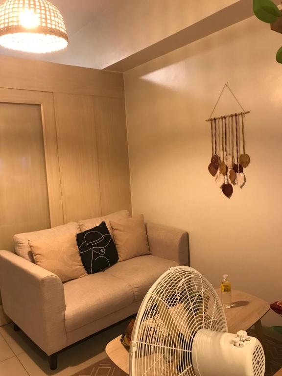 a living room with a couch and a fan at Apartment in Rizal short stay only in Teresa