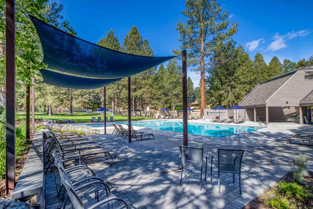 a swimming pool with chairs and a blue net at River Ridge 421A - Meredith Lodging in Bend