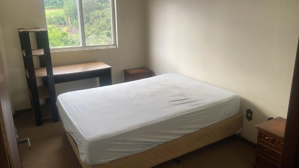 ピラトゥバにあるApartamento na avenidaのベッドと窓のある小さな寝室