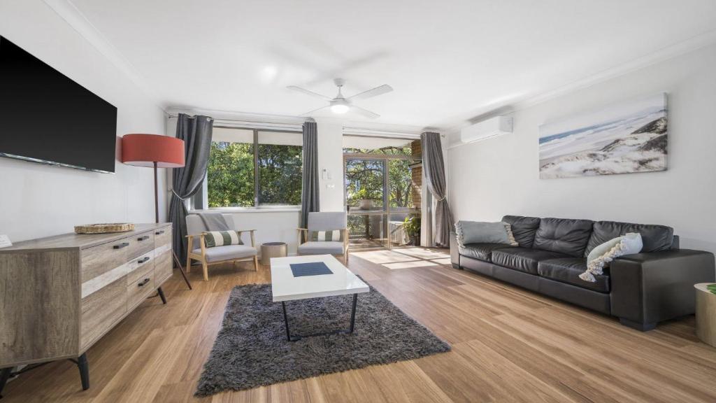 a living room with a couch and a tv at Flynns Beach Seascape in Port Macquarie
