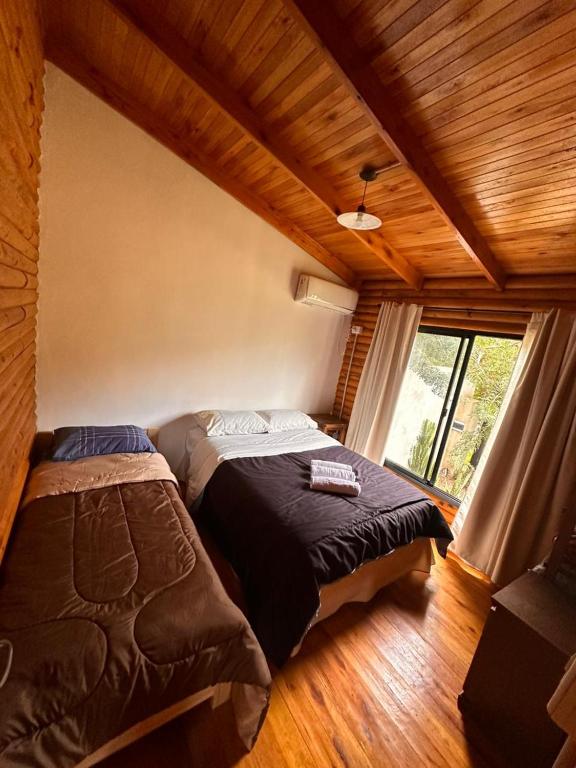 a bedroom with two beds and a large window at Cabañas en Concordia in Concordia
