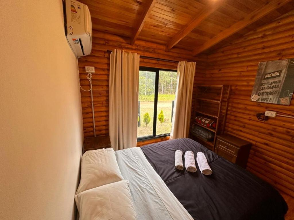 een slaapkamer met een bed met twee slippers erop bij Cabañas en Concordia in Concordia