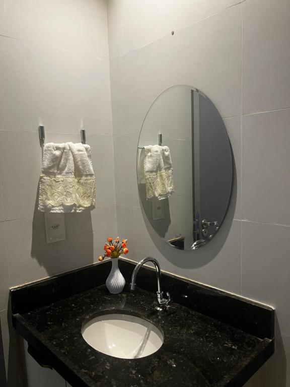 een badkamer met een wastafel met spiegel en handdoeken bij Apartamento Cabedelo - Intermares Beach in Cabedelo