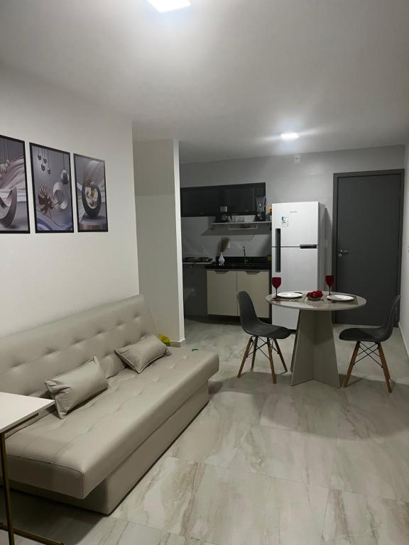 a living room with a couch and a table and a refrigerator at Belize flat praia de Intermares in Cabedelo