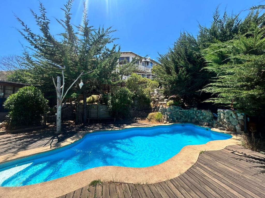 una piscina in un cortile con terrazza in legno di Floresta Concón Mantagua a Concón