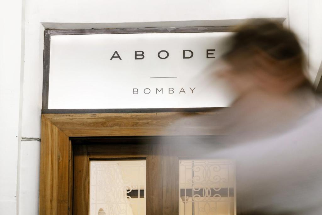 a woman walks past the entrance to a door to abode bambbury at Abode Bombay in Mumbai