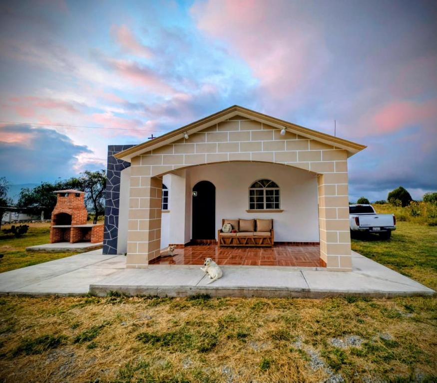 einem Hund, der vor einem Gebäude sitzt in der Unterkunft Casa Rancho El Capulín en Grutas de Tolantongo 