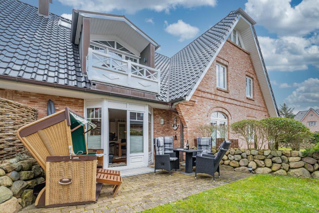 a house with a patio with a table and chairs at Godewind App 5 in Westerland
