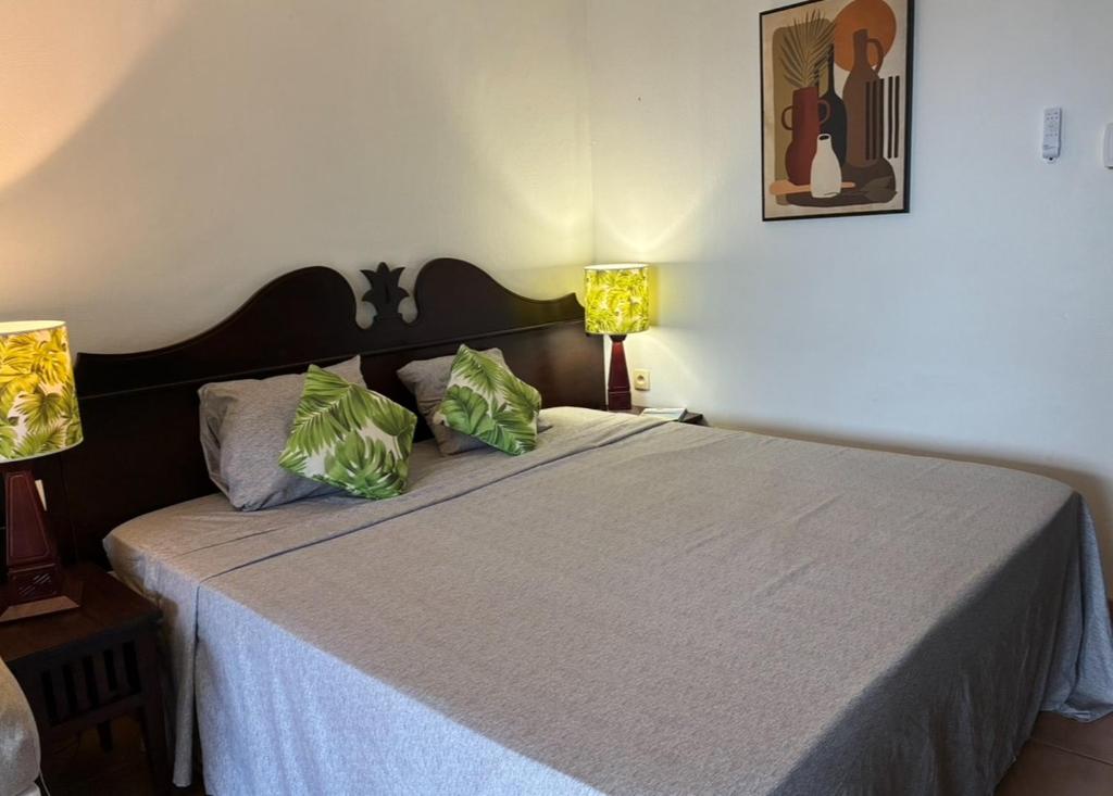 AYOUNAKA, Appartement cosy avec plage terrasse & piscine في Courcelles Sucrerie: غرفة نوم بسرير كبير مع مصباحين