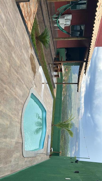 een schilderij van een zwembad aan de zijkant van een gebouw bij Casa vista da serra verde in Santana do Riacho