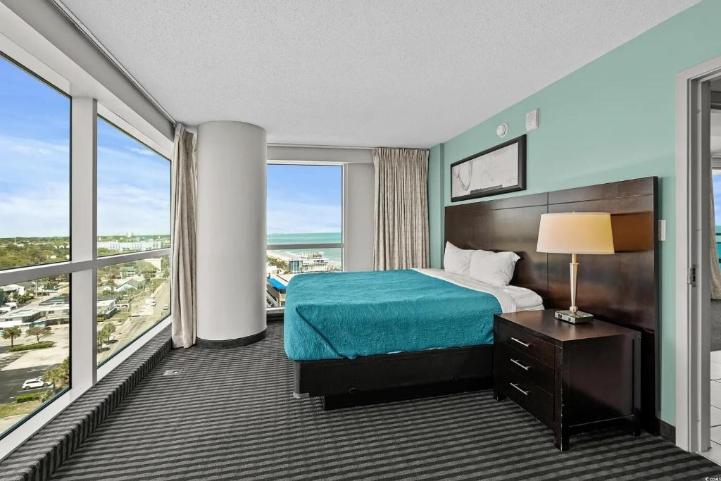 ein Hotelzimmer mit einem Bett und einem großen Fenster in der Unterkunft Glass Wrapped Around Corner Unit Unbeatable View in Myrtle Beach
