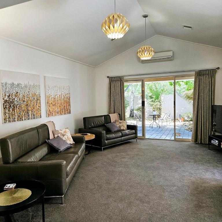 sala de estar con 2 sofás de cuero y patio en Garden Retreat on Orr, en Shepparton