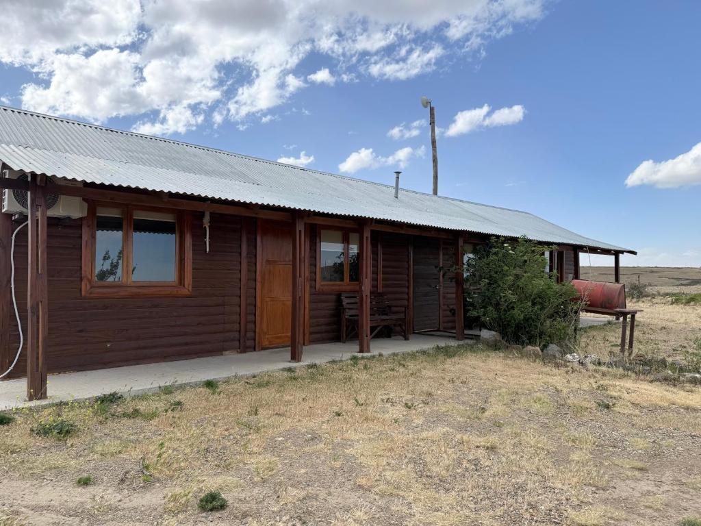 圣胡利安港Cabañas La Sonrisa的田野中间的小木屋