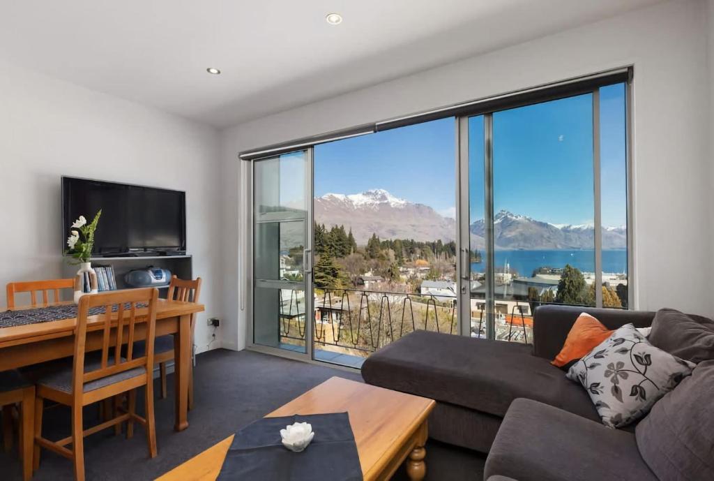 a living room with a view of the water and mountains at Ballarat Bungalow in Queenstown