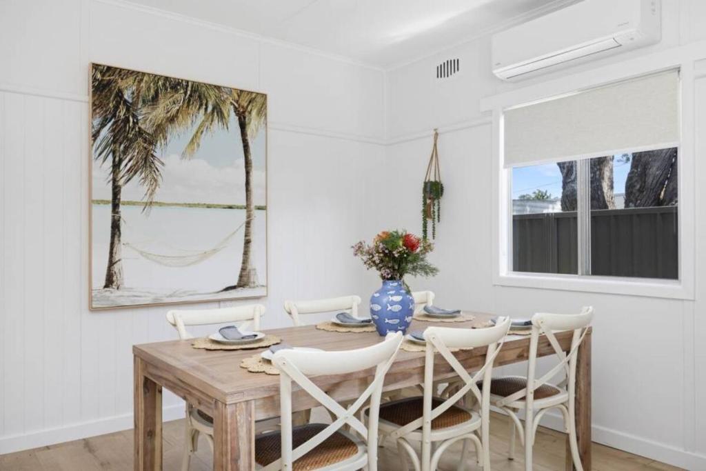 ein Esszimmer mit einem Holztisch und Stühlen in der Unterkunft Nans at Northy - modern river cottage in North Haven