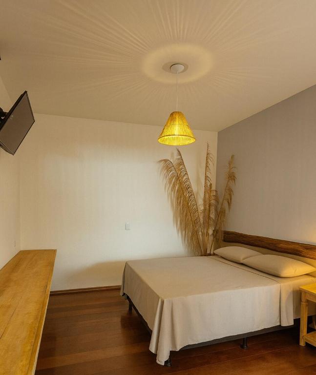 a bedroom with a bed and a yellow lamp at Studio Privativo aprox 2,7 km Centro, Praia Clube c Ar Condicionado in Uberlândia