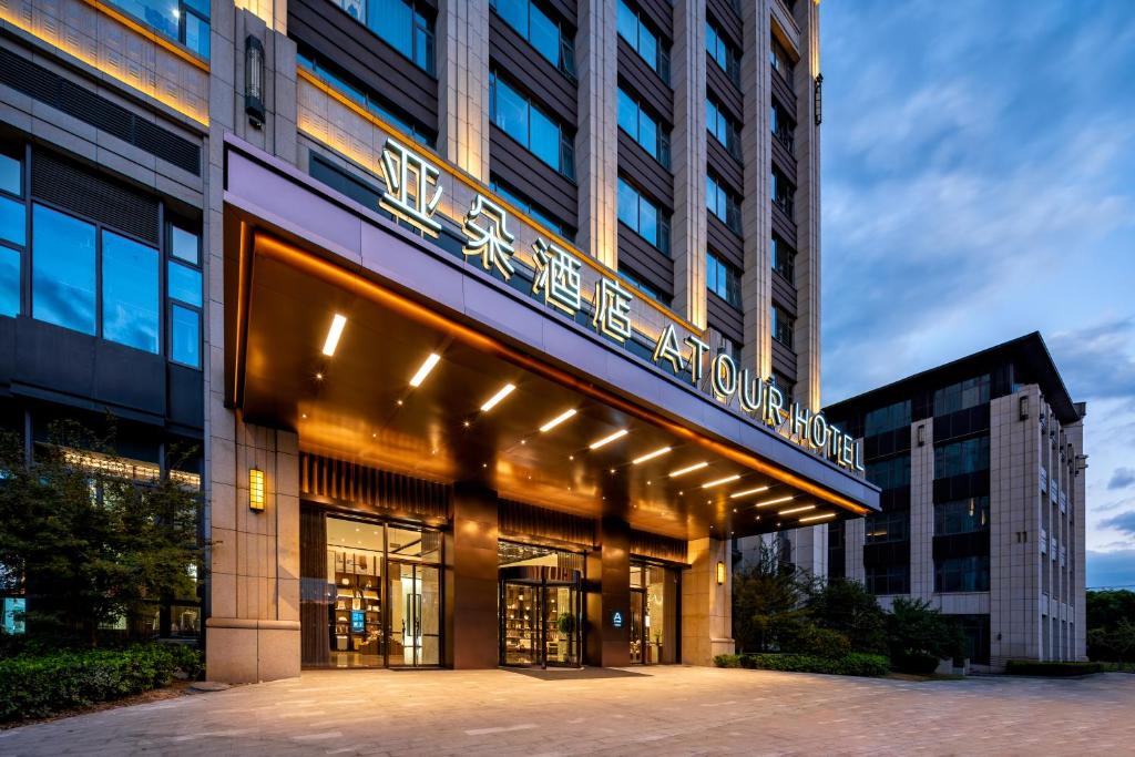 a building with a sign on the front of it at Atour Hotel Jiading Nanxiang in Jiading