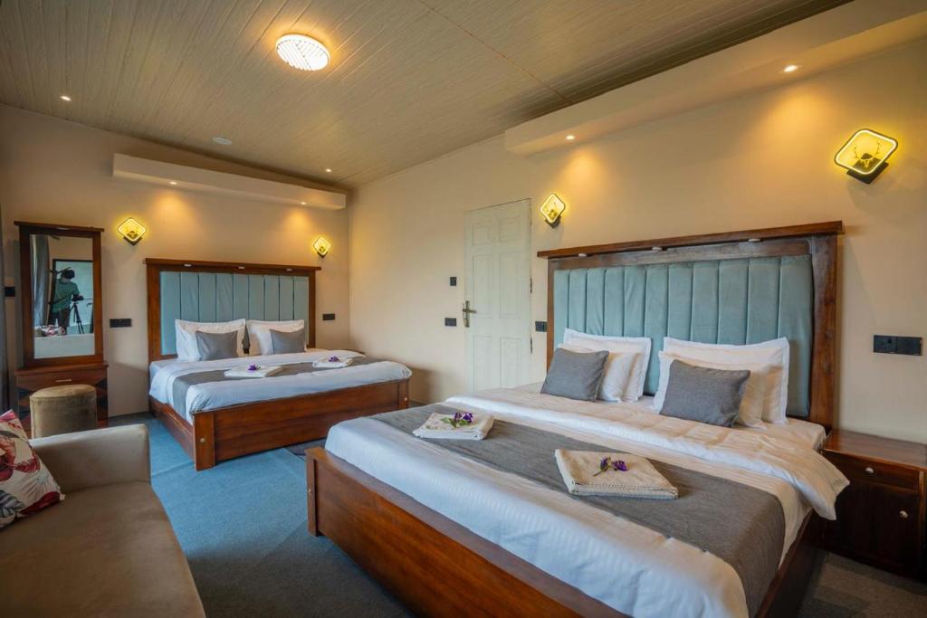 a hotel room with two beds and a couch at Lavee Villa Ella in Ella