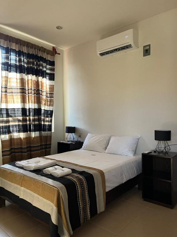 a bedroom with a bed and a window at Casa Penélope in Puerto Ángel
