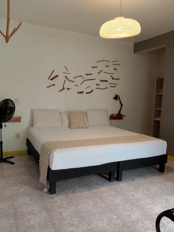 a bed in a room with a sign on the wall at Un Sueño Valle de Huajes in Oaxaca City