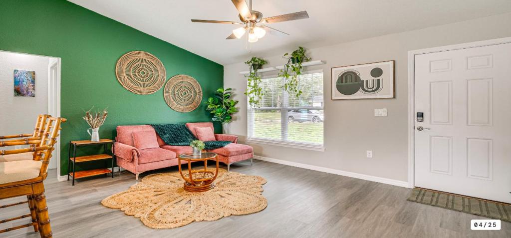 un soggiorno con pareti verdi, divano e tavolo di Rainbow Springs Kozy Getaway a Dunnellon