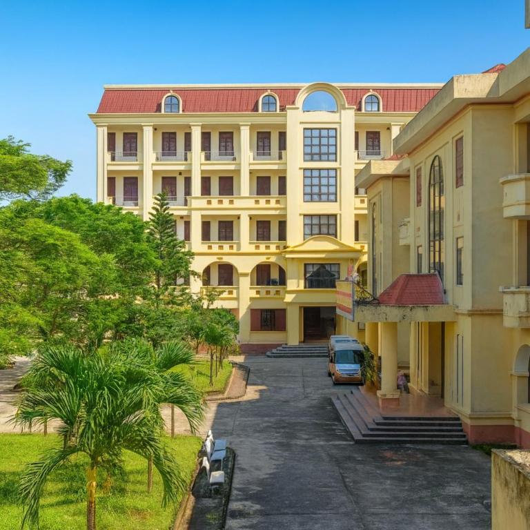 a large yellow building with a car parked in front at Cửa Đại Beach Hotel in Hoi An