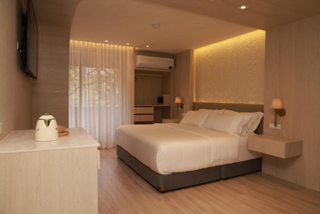 een slaapkamer met een groot wit bed en een raam bij VPV Suites & Casino in Medellín