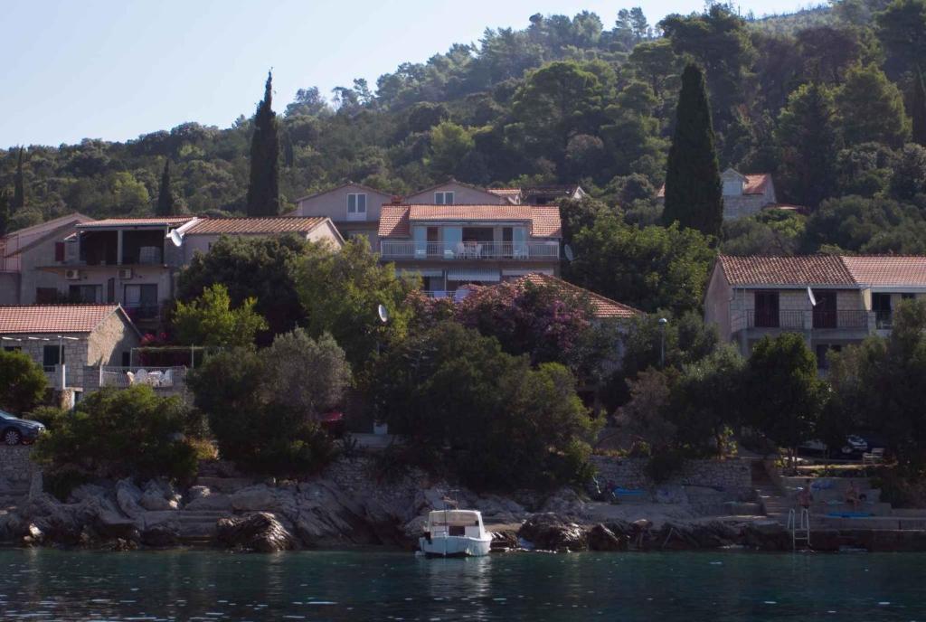 a small boat in the water in front of houses at Apartments Jozica in Brna - Insel Korcula 6371 in Brna