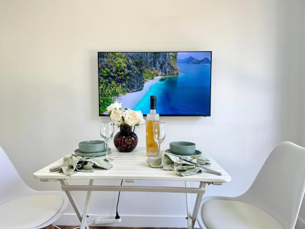 a white table with a tv on a white wall at Studio in Belmont | Easy to City & Airport in Brisbane