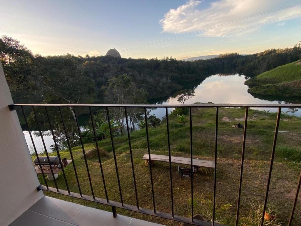 a balcony with a bench and a view of a river at Nakawe Guatape in Guatapé