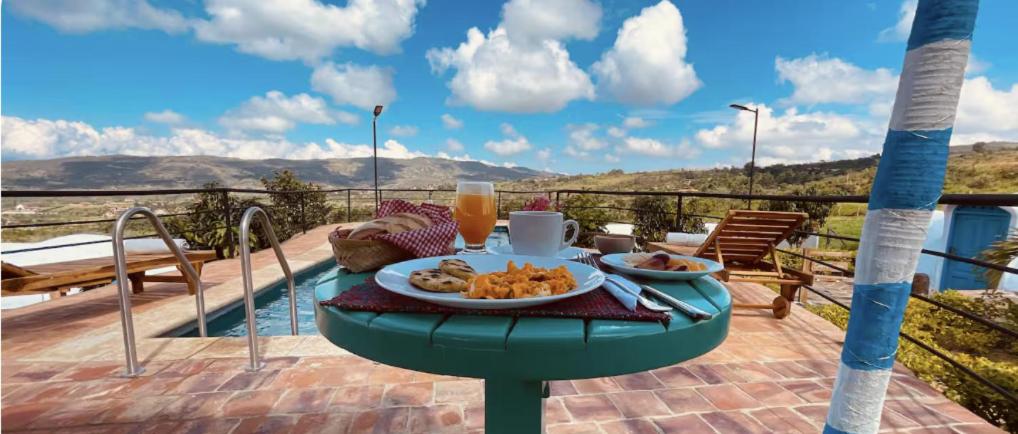 Una mesa con un plato de comida en un balcón. en Glamping de Ensueño con Piscina en Barichara, en Barichara