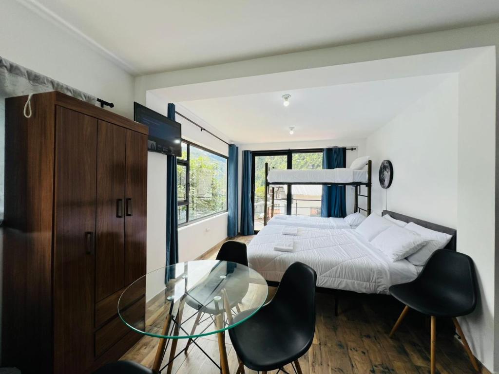 Un dormitorio con una cama y una mesa de cristal. en Moon View Suite, en Baños
