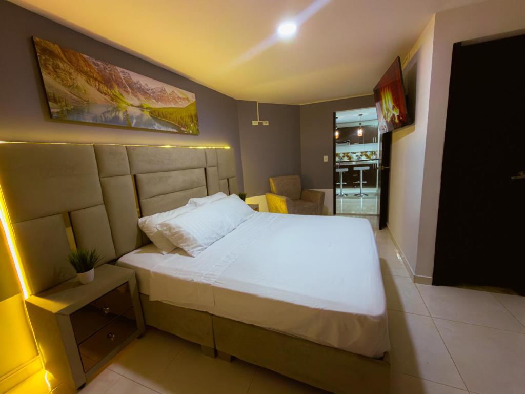 a bedroom with a large bed with a white bedspread at Amplio Y Lujoso Apartasuite En El Centro in Cartago