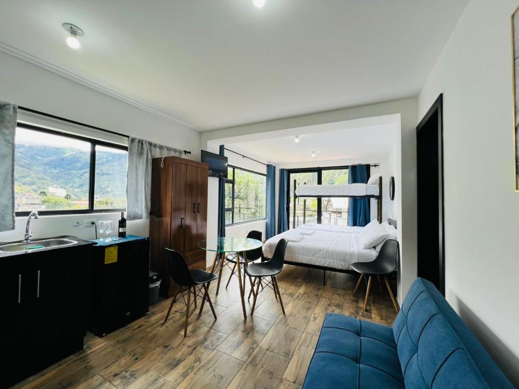 sala de estar con sofá azul y dormitorio en Skyline Retreat Suite, en Baños