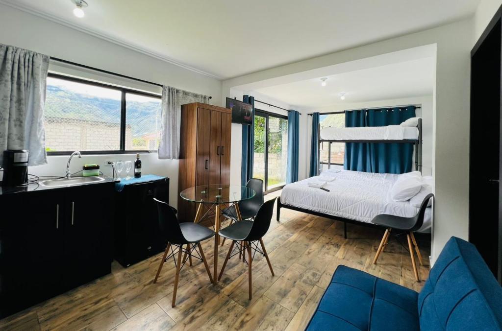 Un dormitorio con una cama y una mesa y sillas. en Urban Ground Suite, en Baños