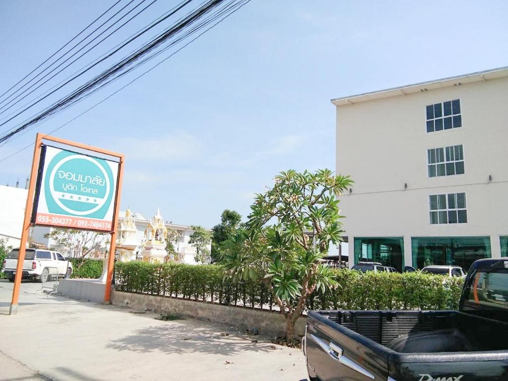 een vrachtwagen geparkeerd voor een gebouw met een bord bij Jommalai Boutique Hotel in Ban Nong Chaeng