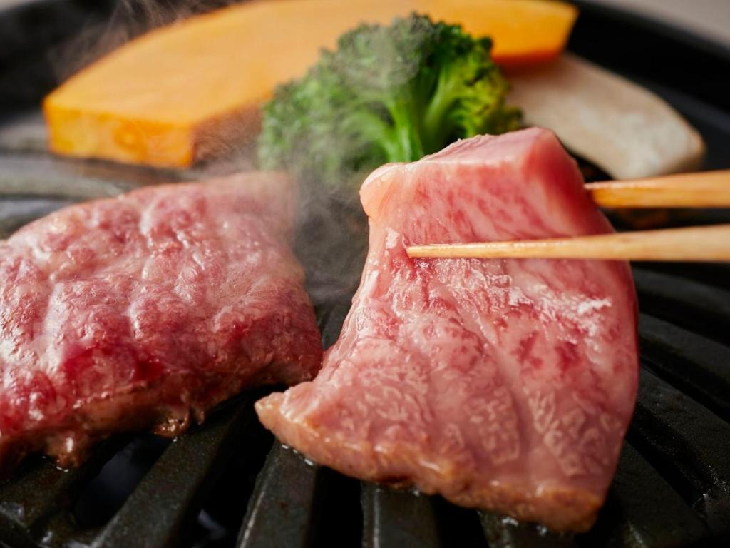 Deux morceaux de viande et du brocoli sur un gril dans l'établissement KAMENOI HOTEL Arima, à Kobe