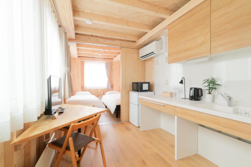 a kitchen with a counter and a desk in a room at SMA MO inn Chitose in Chitose