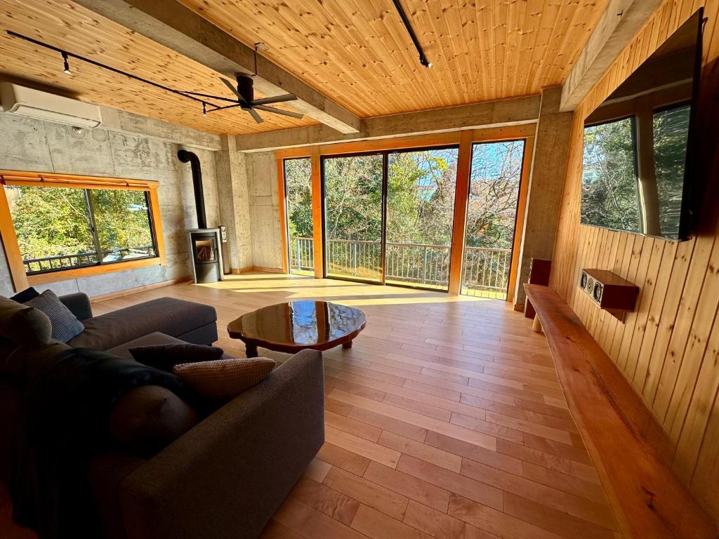 TATEYA VACATION Cozy Spacious Suite by the creek Near Hot Springs في Akiruno: غرفة معيشة بها أريكة وطاولة