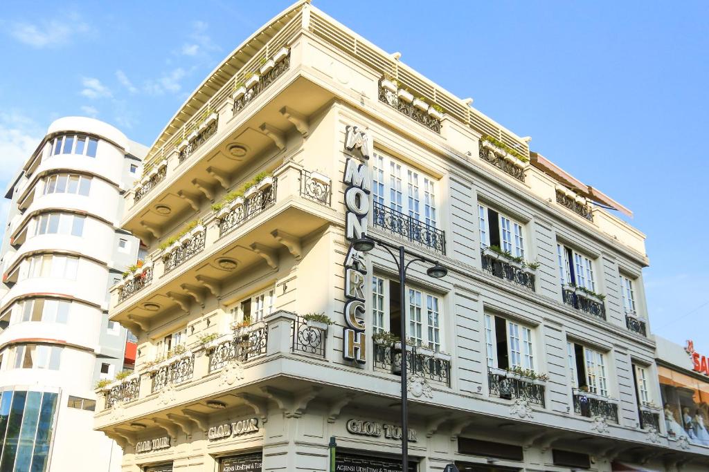 a white building with a sign on the side of it at Hotel Monarch in Elbasan